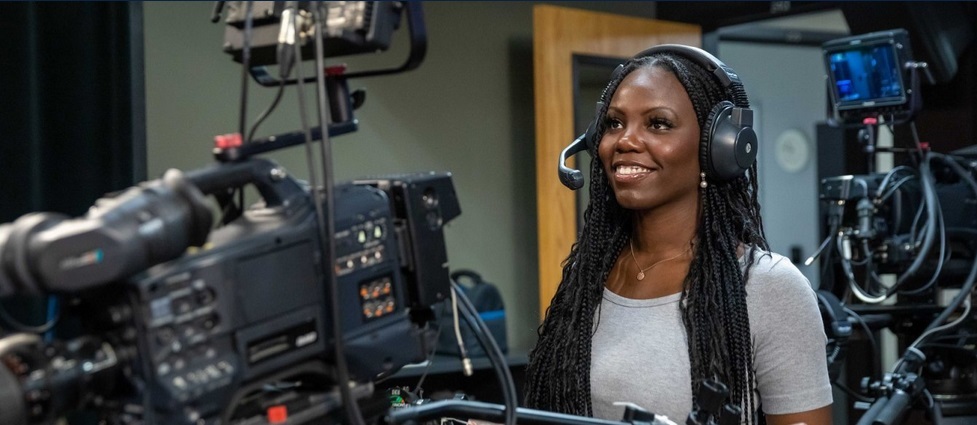 Student working a video camera.